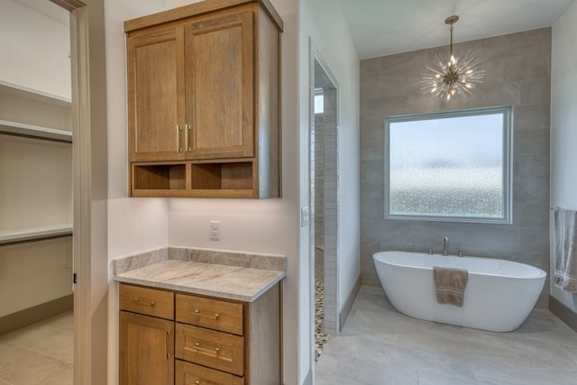 208 E Lakeshore Dr, Sunrise Beach, TX 78643 - bathroom with a chandelier, a soaking tub, a spacious closet, and tile patterned flooring