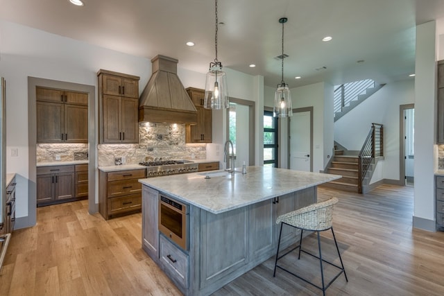 208 E Lakeshore Dr, Sunrise Beach, TX 78643 - kitchen featuring a sink, premium range hood, stainless steel gas cooktop, light wood finished floors, and recessed lighting