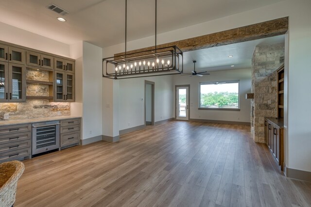 208 E Lakeshore Dr, Sunrise Beach, TX 78643 - bar with beverage cooler, a ceiling fan, tasteful backsplash, light wood-style floors, and baseboards
