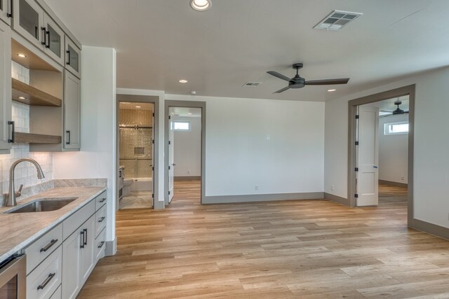 208 E Lakeshore Dr, Sunrise Beach, TX 78643 - kitchen with a sink, a ceiling fan, baseboards, recessed lighting, and decorative backsplash