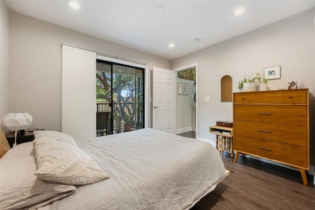 935 La Posada Dr Unit 243, Austin, TX 78752 - bedroom featuring access to outside, dark wood-type flooring, recessed lighting, and arched walkways