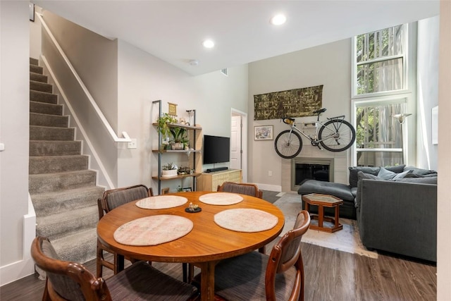 935 La Posada Dr Unit 243, Austin, TX 78752 - dining room featuring a fireplace with flush hearth, stairs, wood finished floors, baseboards, and recessed lighting