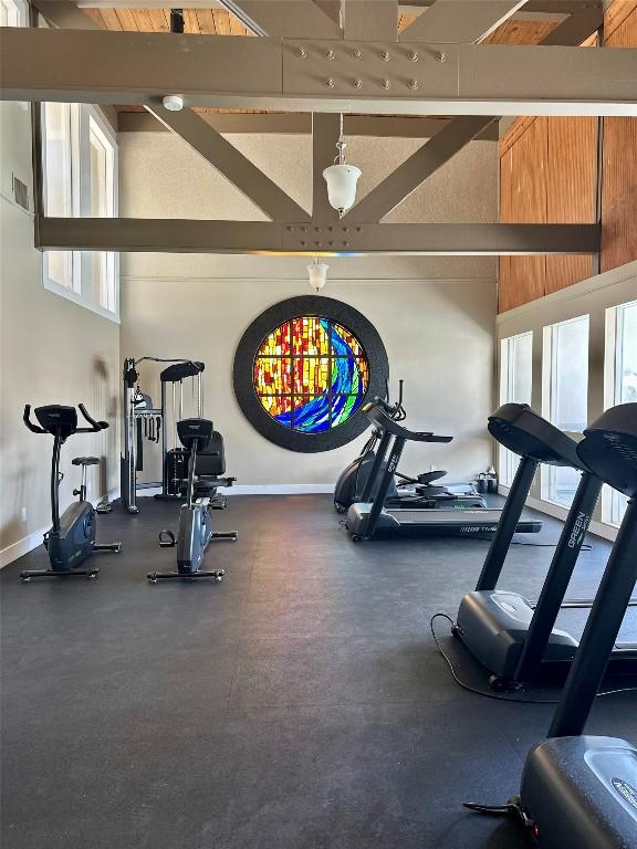 935 La Posada Dr Unit 243, Austin, TX 78752 - exercise room featuring baseboards and a high ceiling