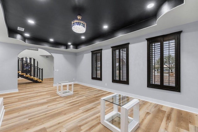 129 Cedar Dr, Horseshoe Bay, TX 78657 - unfurnished room featuring arched walkways, a tray ceiling, baseboards, wood finished floors, and recessed lighting