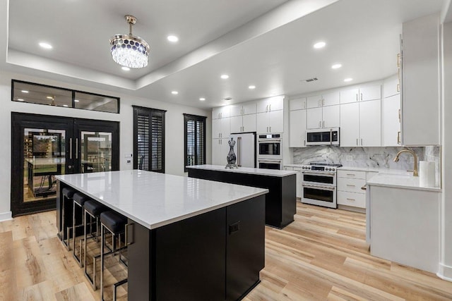 129 Cedar Dr, Horseshoe Bay, TX 78657 - kitchen with high end appliances, a kitchen island, a sink, tasteful backsplash, and light wood-style floors