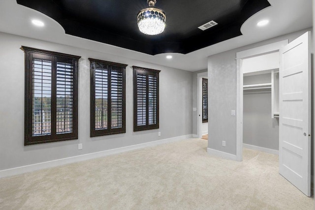 129 Cedar Dr, Horseshoe Bay, TX 78657 - unfurnished bedroom featuring carpet, a tray ceiling, baseboards, and a walk in closet