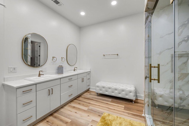 129 Cedar Dr, Horseshoe Bay, TX 78657 - full bath featuring double vanity, a marble finish shower, recessed lighting, wood finished floors, and baseboards