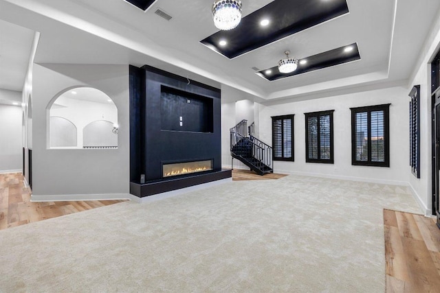 129 Cedar Dr, Horseshoe Bay, TX 78657 - unfurnished living room with a raised ceiling, baseboards, stairway, arched walkways, and a fireplace