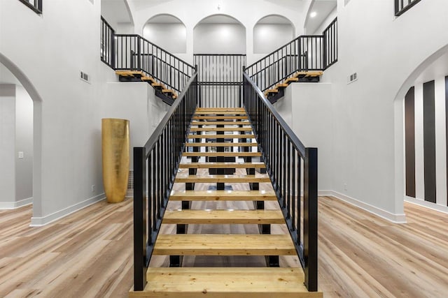 129 Cedar Dr, Horseshoe Bay, TX 78657 - staircase featuring a high ceiling, wood finished floors, baseboards, and arched walkways