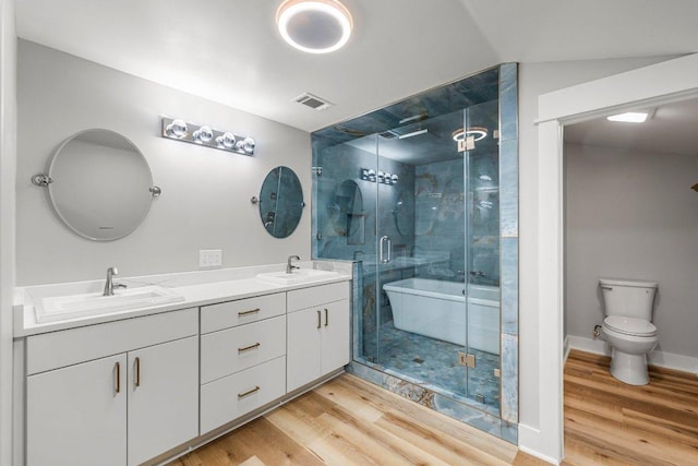 129 Cedar Dr, Horseshoe Bay, TX 78657 - full bathroom featuring double vanity, wood finished floors, a shower stall, and toilet