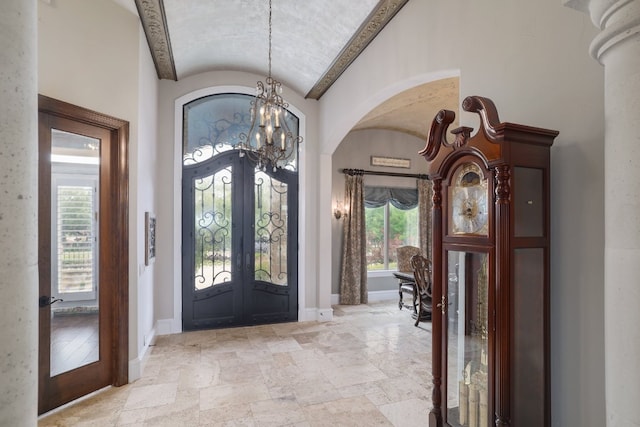 700 Zen Gardens Ter, Austin, TX 78732 - entrance foyer with french doors, arched walkways, a chandelier, stone tile floors, and high vaulted ceiling