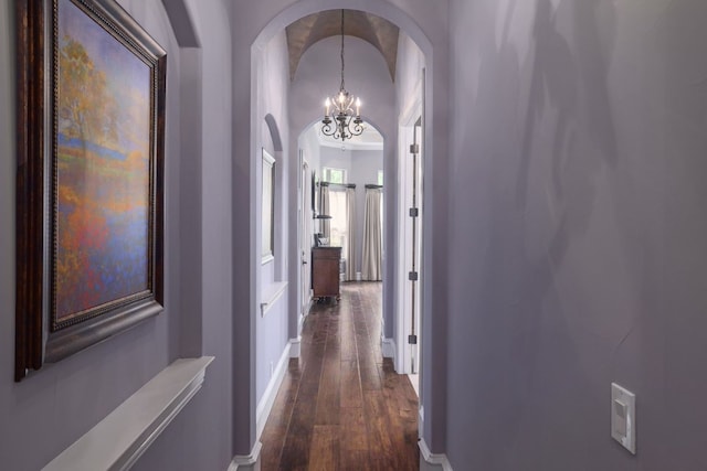 700 Zen Gardens Ter, Austin, TX 78732 - hallway featuring arched walkways, dark wood-style floors, a chandelier, baseboards, and vaulted ceiling