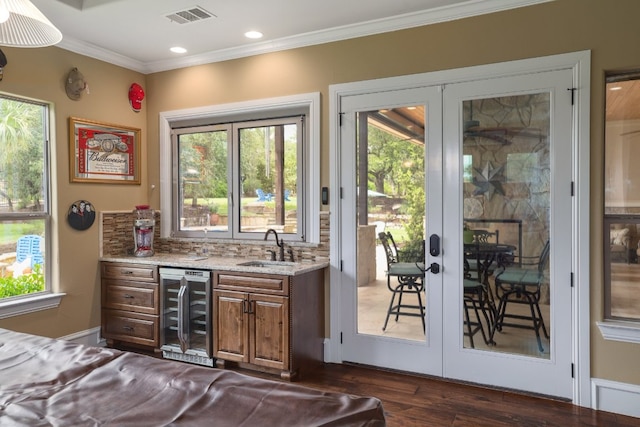 700 Zen Gardens Ter, Austin, TX 78732 - bar with wine cooler, french doors, dark wood finished floors, ornamental molding, and tasteful backsplash