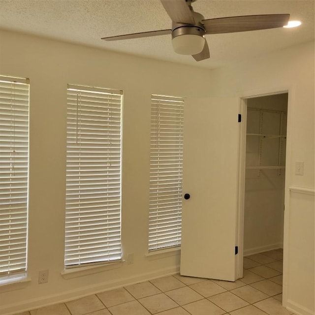 405 S Blue Ridge Parkway, Cedar Park, TX 78613 - unfurnished bedroom featuring a closet, light tile patterned flooring, a spacious closet, a ceiling fan, and baseboards