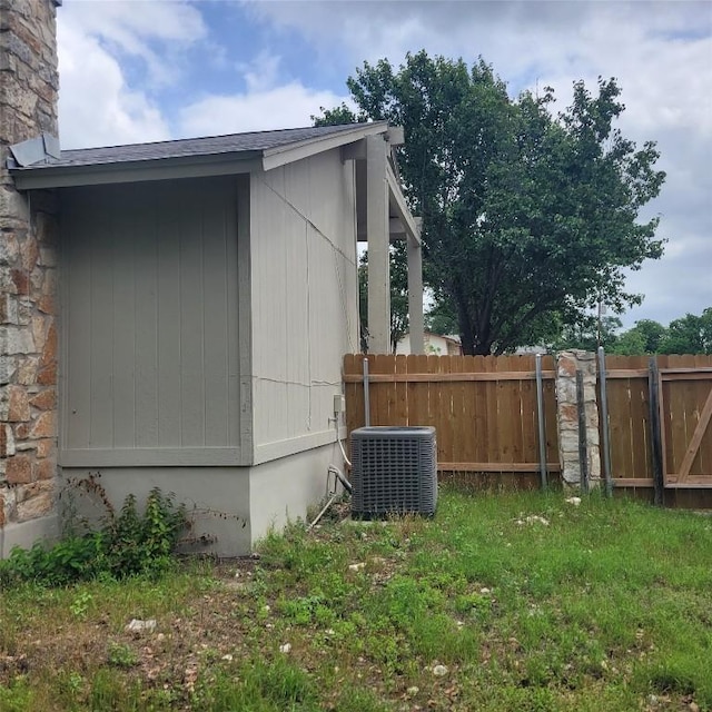 405 S Blue Ridge Parkway, Cedar Park, TX 78613 - view of side of property featuring central AC unit, a chimney, a shingled roof, and stone siding