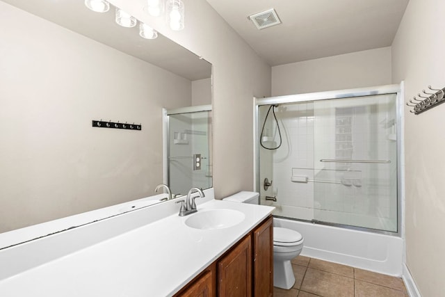 755 Hometown Pkwy, Kyle, TX 78640 - bathroom featuring toilet, vanity, enclosed tub / shower combo, tile patterned flooring, and baseboards