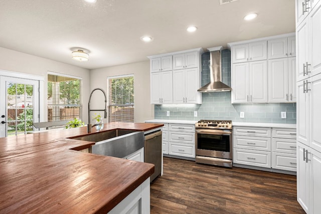 755 Hometown Pkwy, Kyle, TX 78640 - kitchen with stainless steel appliances, wall chimney exhaust hood, butcher block counters, a sink, and decorative backsplash