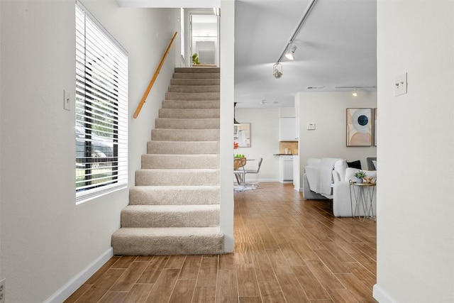 2814 Windsor Rd, Austin, TX 78703 - stairway featuring rail lighting, wood finished floors, and baseboards