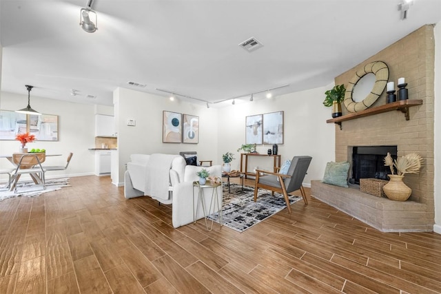 2814 Windsor Rd, Austin, TX 78703 - living area featuring track lighting, light wood-style floors, a fireplace, and baseboards