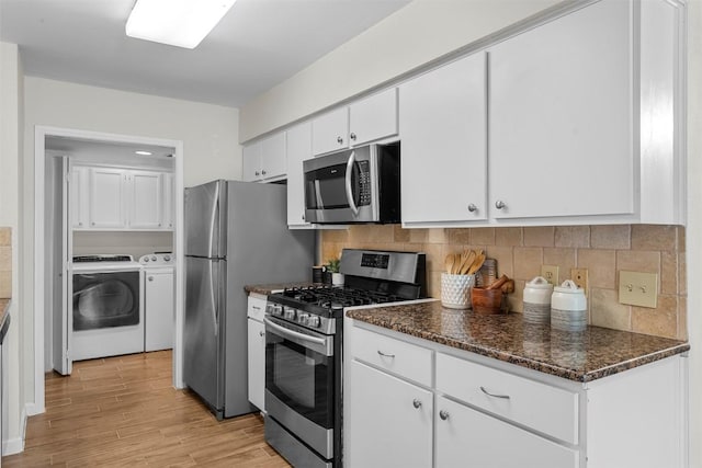 2814 Windsor Rd, Austin, TX 78703 - kitchen with stainless steel appliances, washer and dryer, white cabinetry, light wood finished floors, and backsplash