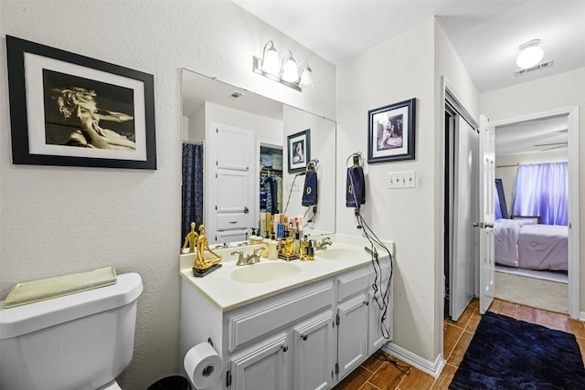 2814 Windsor Rd, Austin, TX 78703 - ensuite bathroom featuring toilet, double vanity, wood finished floors, and a textured wall
