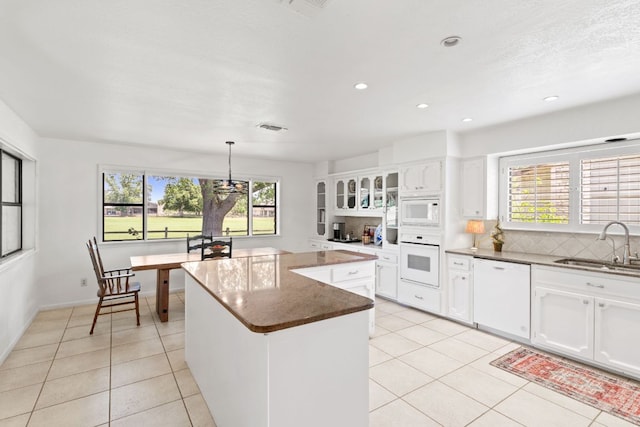 618 Hi Stirrup, Horseshoe Bay, TX 78657 - kitchen with white appliances, a sink, light tile patterned floors, a center island, and decorative backsplash