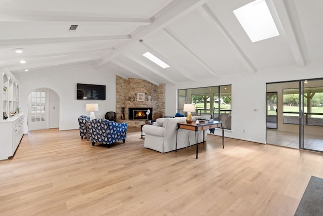 618 Hi Stirrup, Horseshoe Bay, TX 78657 - living area featuring a fireplace, a skylight, light wood-type flooring, and arched walkways