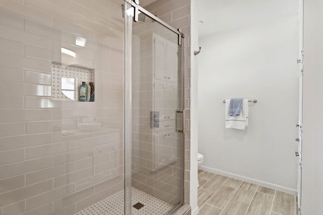 618 Hi Stirrup, Horseshoe Bay, TX 78657 - full bathroom with toilet, a shower stall, baseboards, and wood finished floors