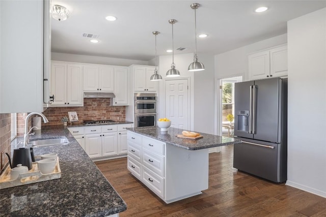 3437 Mulberry Creek Dr, Austin, TX 78732 - kitchen featuring appliances with stainless steel finishes, a sink, under cabinet range hood, backsplash, and white cabinetry