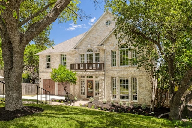 3437 Mulberry Creek Dr, Austin, TX 78732 - rear view of house featuring stone siding, a balcony, a patio, and an attached garage