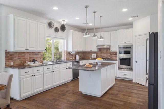 3437 Mulberry Creek Dr, Austin, TX 78732 - kitchen featuring stainless steel appliances, a sink, a kitchen island, white cabinets, and recessed lighting