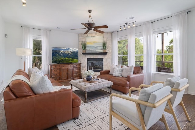 3437 Mulberry Creek Dr, Austin, TX 78732 - living room featuring ceiling fan, a stone fireplace, wood finished floors, and rail lighting