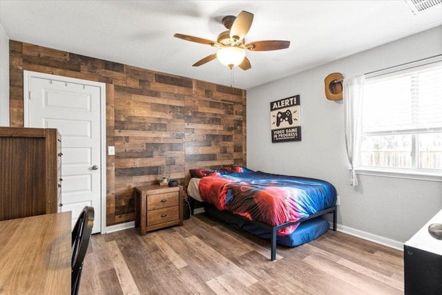 2313 Jake Pickle Pass, Leander, TX 78641 - bedroom featuring wood walls, wood finished floors, and a ceiling fan