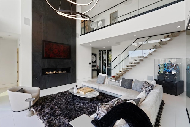 204 Wennmohs Pl, Horseshoe Bay, TX 78657 - tiled living room featuring a towering ceiling, stairs, a large fireplace, and a chandelier