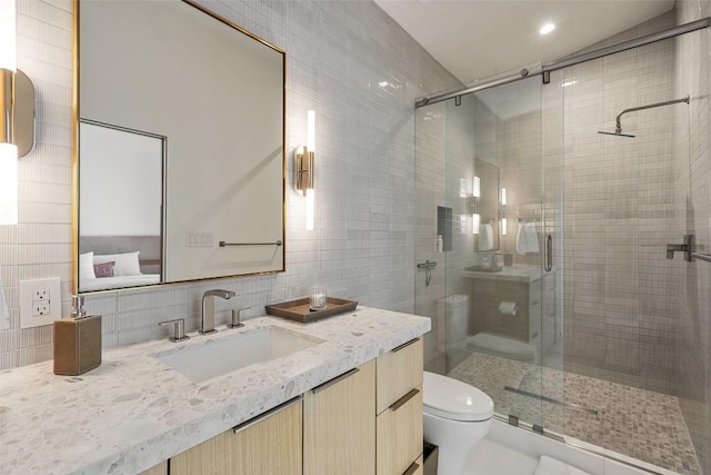 204 Wennmohs Pl, Horseshoe Bay, TX 78657 - bathroom featuring tile walls, backsplash, vanity, toilet, and a stall shower