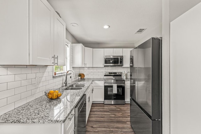 1302 Phyllis Dr, Copperas Cove, TX 76522 - kitchen with appliances with stainless steel finishes, a sink, white cabinets, light stone counters, and tasteful backsplash