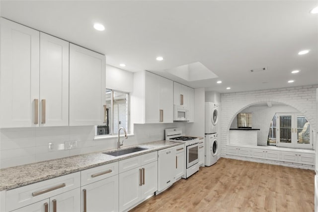 4202 N Hills Dr, Austin, TX 78731 - kitchen with stacked washer / drying machine, white appliances, white cabinetry, and recessed lighting