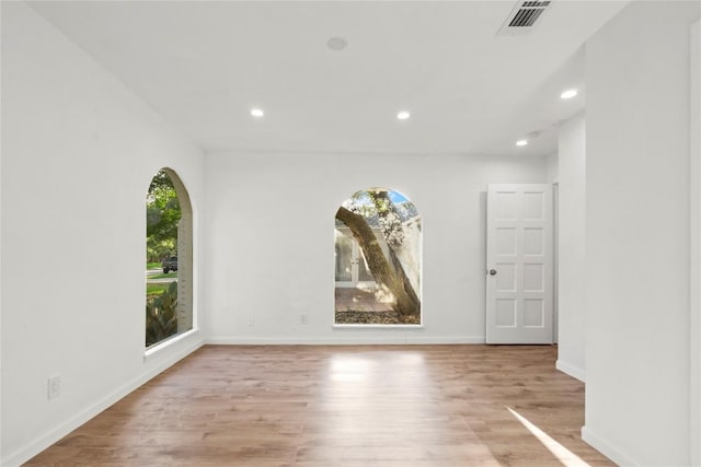 4202 N Hills Dr, Austin, TX 78731 - unfurnished room with plenty of natural light, recessed lighting, light wood-style flooring, and arched walkways