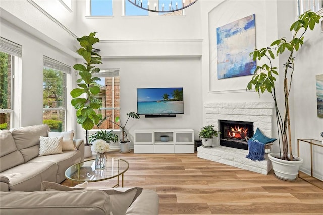 220 Grafton Ln, Austin, TX 78737 - living room featuring a high ceiling, wood finished floors, a fireplace, and a chandelier