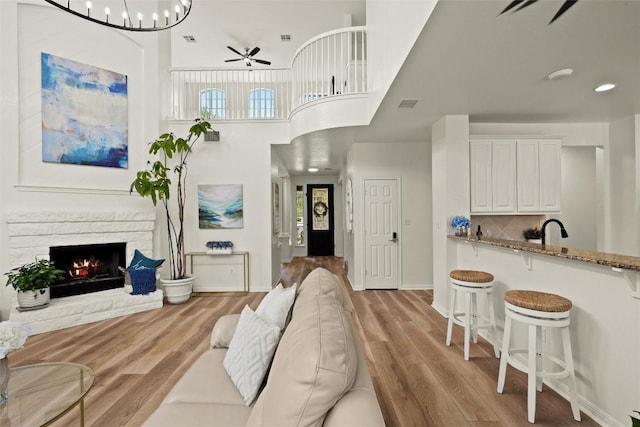 220 Grafton Ln, Austin, TX 78737 - living room with ceiling fan, wood finished floors, a fireplace, a high ceiling, and baseboards