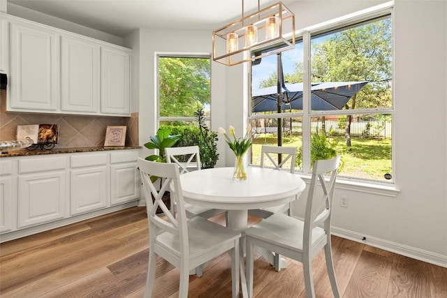 220 Grafton Ln, Austin, TX 78737 - dining area with light wood-style floors, healthy amount of natural light, a chandelier, and baseboards