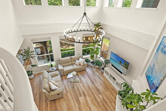 220 Grafton Ln, Austin, TX 78737 - living room with a high ceiling, plenty of natural light, wood finished floors, and a chandelier