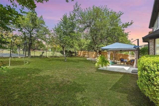 220 Grafton Ln, Austin, TX 78737 - yard at dusk featuring a trampoline, a gazebo, a patio, and an outdoor living space