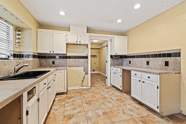 702 Westminster Pl, Round Rock, TX 78664 - kitchen with a sink, white cabinetry, decorative backsplash, light countertops, and recessed lighting