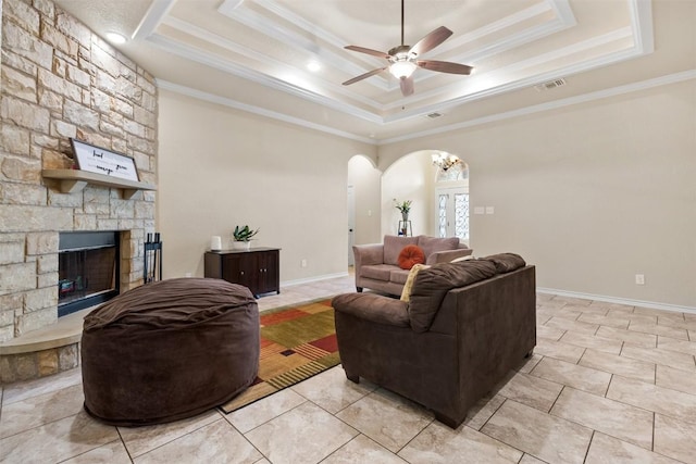 2034 Falling Leaf Ln, Harker Heights, TX 76548 - living area with arched walkways, a tray ceiling, ceiling fan, ornamental molding, and a stone fireplace