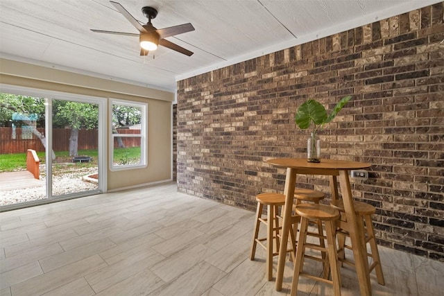 2034 Falling Leaf Ln, Harker Heights, TX 76548 - unfurnished dining area featuring brick wall, a ceiling fan, and light wood-type flooring