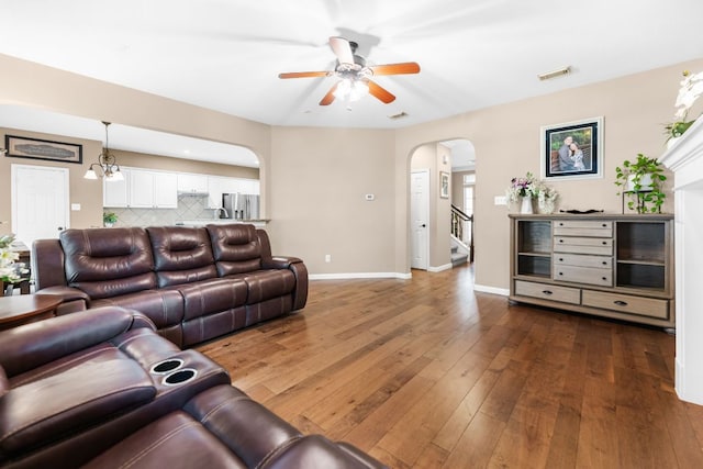 15150 Galena Dr, Austin, TX 78717 - living room featuring arched walkways, a ceiling fan, wood-type flooring, baseboards, and stairway