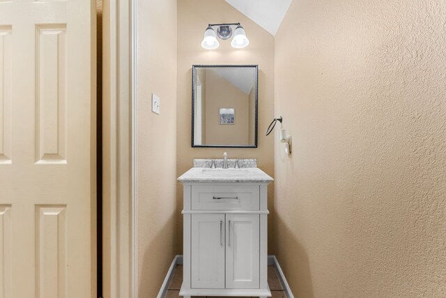 15150 Galena Dr, Austin, TX 78717 - bathroom with baseboards, vanity, and vaulted ceiling