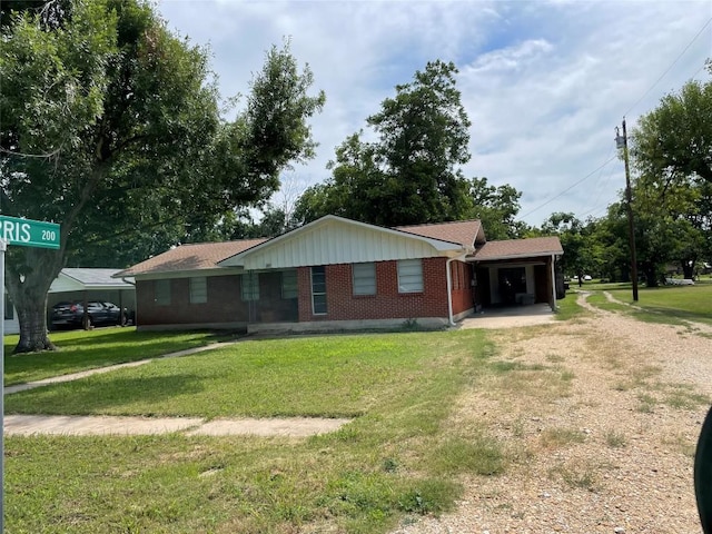 207 N 1st St, Thorndale, TX 76577 - ranch-style home featuring brick siding, dirt driveway, a front yard, and roof with shingles