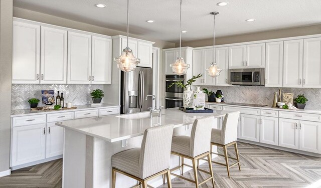 20408 Stelfox St, Manor, TX 78653 - kitchen with appliances with stainless steel finishes, a sink, recessed lighting, decorative backsplash, and white cabinetry